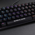 El teclado mecánico gamer Shenlong UMK6100SB se destaca por su formato compacto de 62 teclas, que optimiza el espacio en el escritorio sin perder funcionalidades esenciales